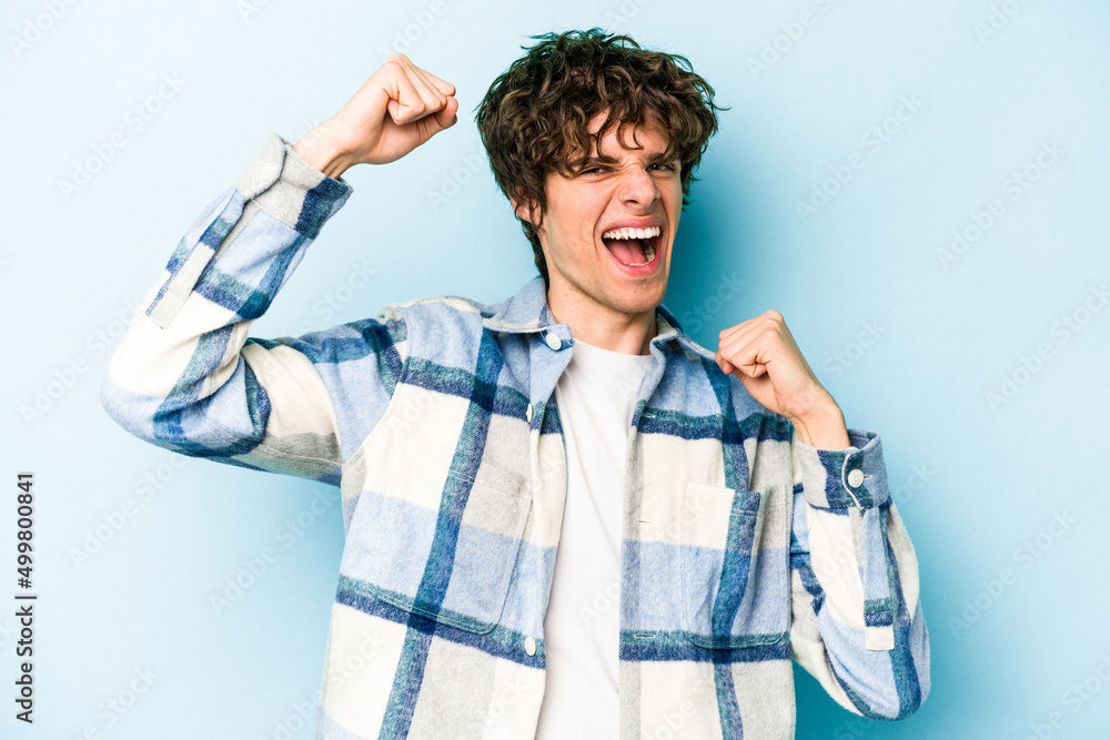 Young caucasian man isolated on blue background cheering carefree and excited. Victory concept. Young caucasian man isolated on blue background cheering carefree and excited. Victory concept.