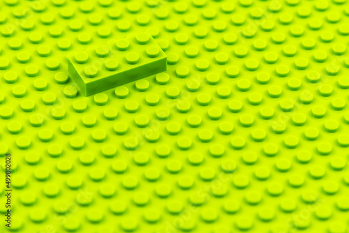 Green plastic toy block on green base