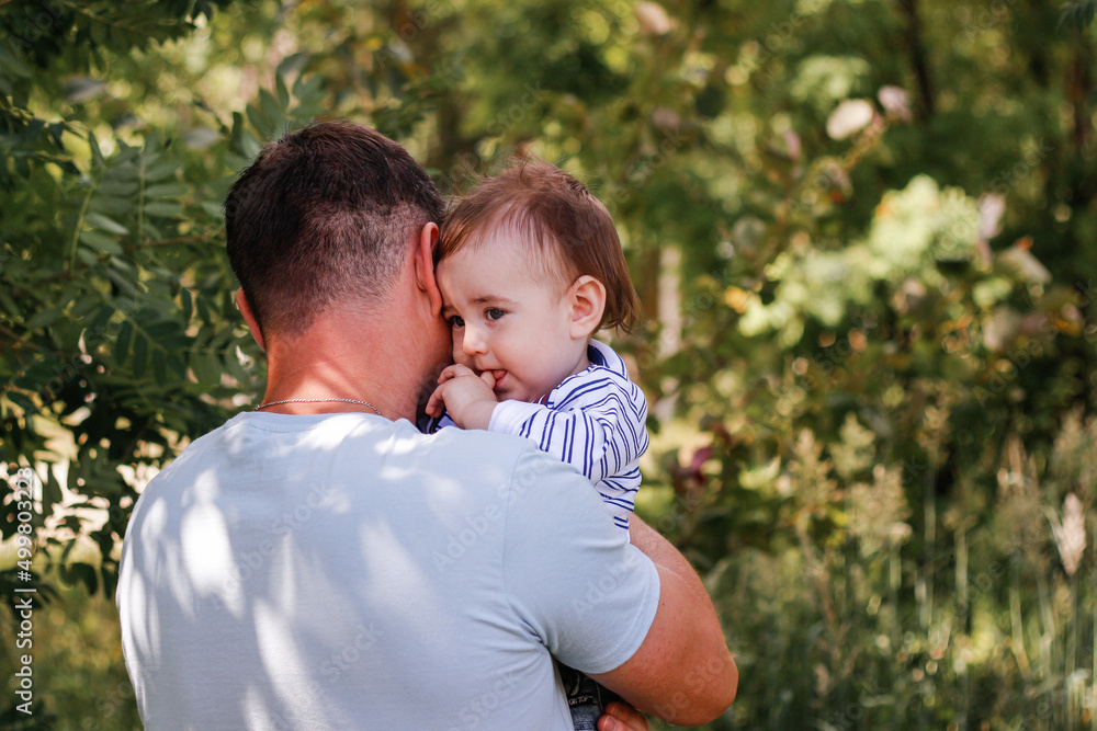 Father hugs his little son against the backdrop of natural nature. Fathers day, fatherhood. Child under father's protection Father hugs his little son against the backdrop of natural nature. Fathers day, fatherhood. Child under father's protection