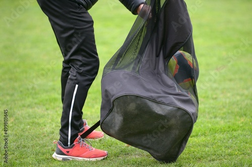 l'assistant ramasse les ballons sur le terrain au football	 photo