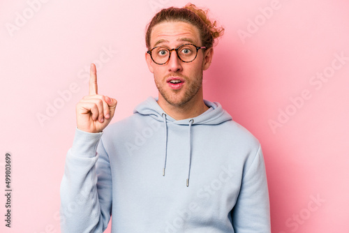 Young caucasian man isolated on pink background having an idea, inspiration concept.