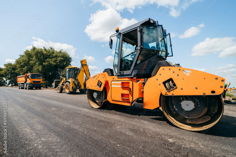 Vibratory asphalt roller compactor compacting new asphalt pavement. Road service repairs the highway Vibratory asphalt roller compactor compacting new asphalt pavement. Road service repairs the highway