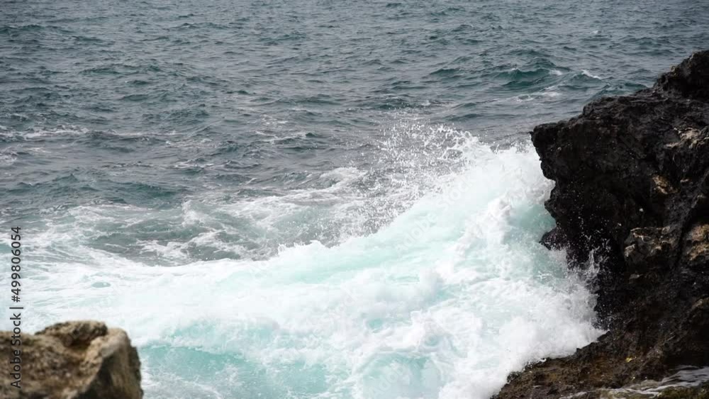 Slow motion static of ocean waves swirling and crashing and covering rocks Slow motion static of ocean waves swirling and crashing and covering rocks