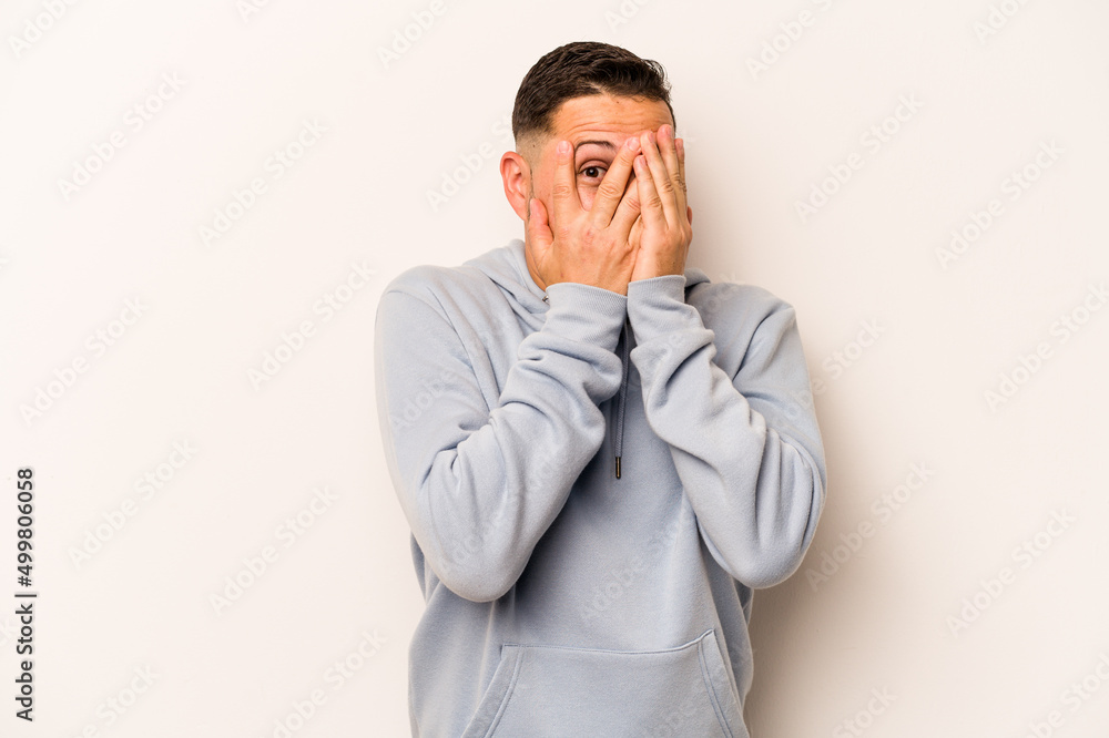 Young hispanic man isolated on white background blink through fingers frightened and nervous. Young hispanic man isolated on white background blink through fingers frightened and nervous.
