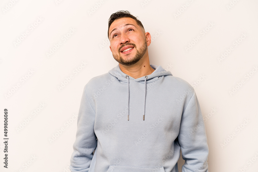 Young hispanic man isolated on white background relaxed and happy laughing, neck stretched showing teeth. Young hispanic man isolated on white background relaxed and happy laughing, neck stretched showing teeth.