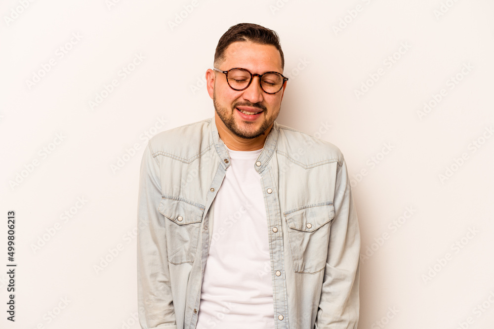 Young hispanic man isolated on white background laughs and closes eyes, feels relaxed and happy. Young hispanic man isolated on white background laughs and closes eyes, feels relaxed and happy.