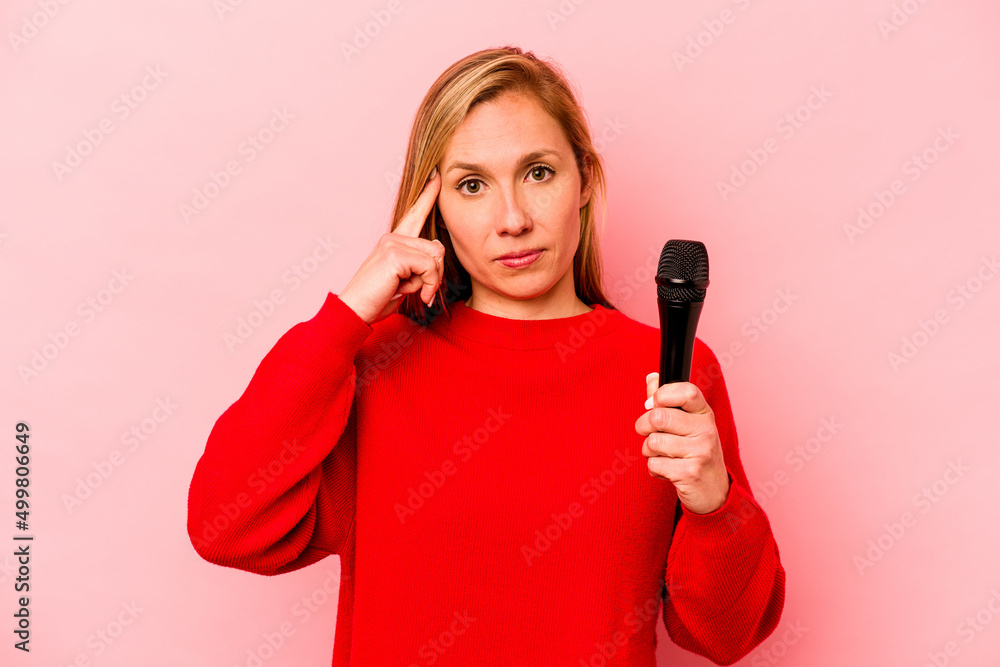 Young caucasian singer woman isolated on pink background pointing temple with finger, thinking, focused on a task. Young caucasian singer woman isolated on pink background pointing temple with finger, thinking, focused on a task.