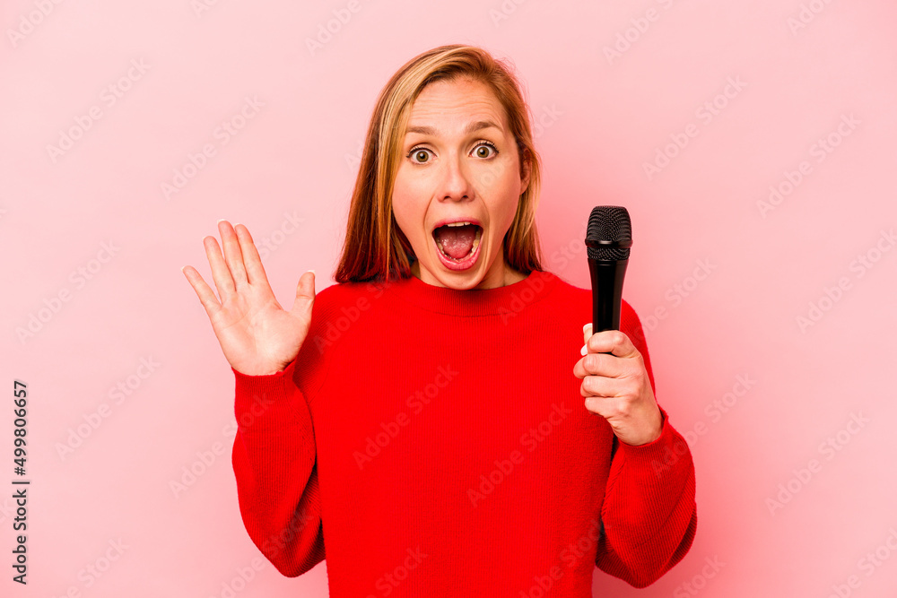 Young caucasian singer woman isolated on pink background surprised and shocked. Young caucasian singer woman isolated on pink background surprised and shocked.