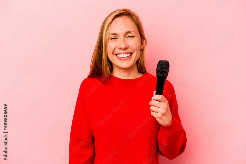 Young caucasian singer woman isolated on pink background laughing and having fun. Young caucasian singer woman isolated on pink background laughing and having fun.