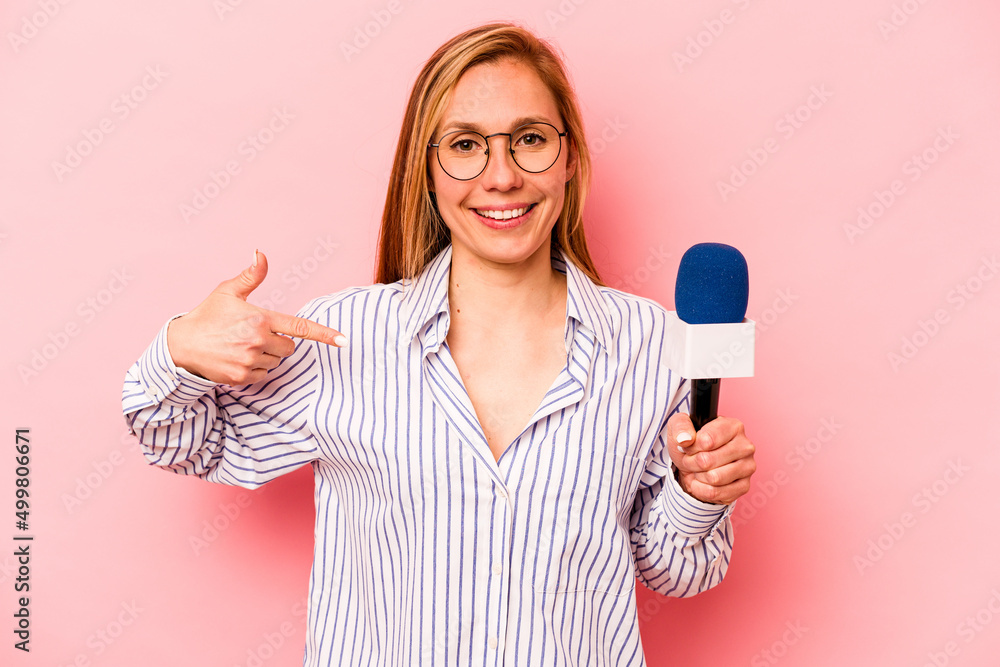 Young caucasian TV presenter woman isolated on pink background person pointing by hand to a shirt copy space, proud and confident Young caucasian TV presenter woman isolated on pink background person pointing by hand to a shirt copy space, proud and confident