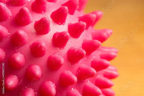 Pink rubber ball with spikes. The concept of a pathogenic virus. Covid coronovirus pandemic.