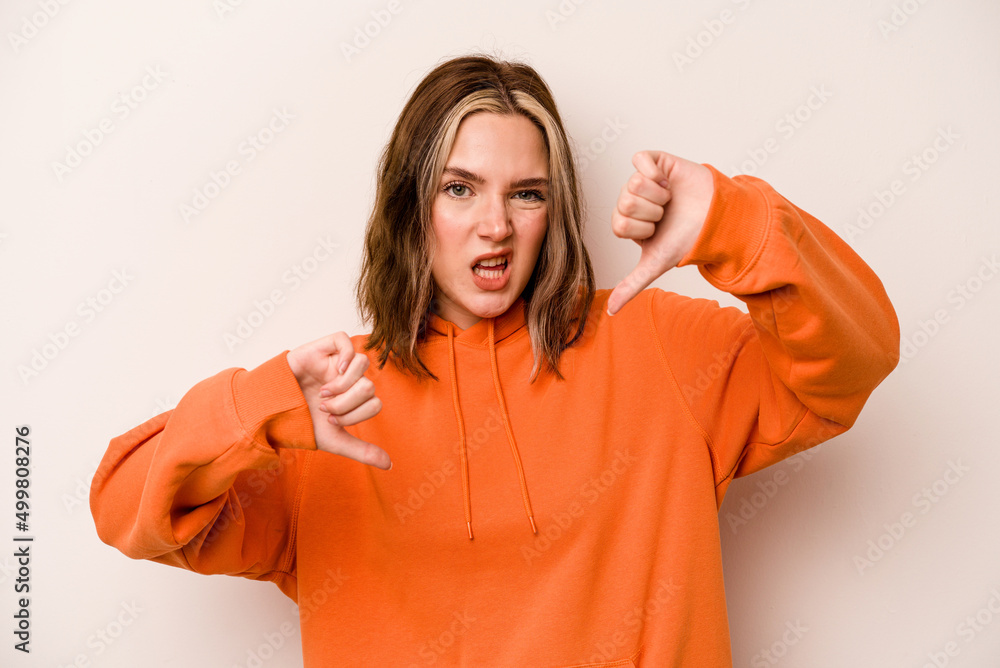 Young caucasian woman isolated on white background showing thumb down and expressing dislike. Young caucasian woman isolated on white background showing thumb down and expressing dislike.