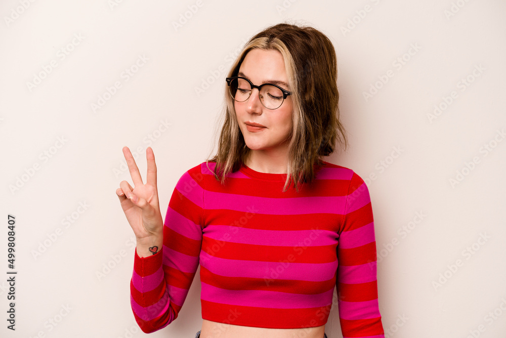 Young caucasian woman isolated on white background joyful and carefree showing a peace symbol with fingers. Young caucasian woman isolated on white background joyful and carefree showing a peace symbol with fingers.