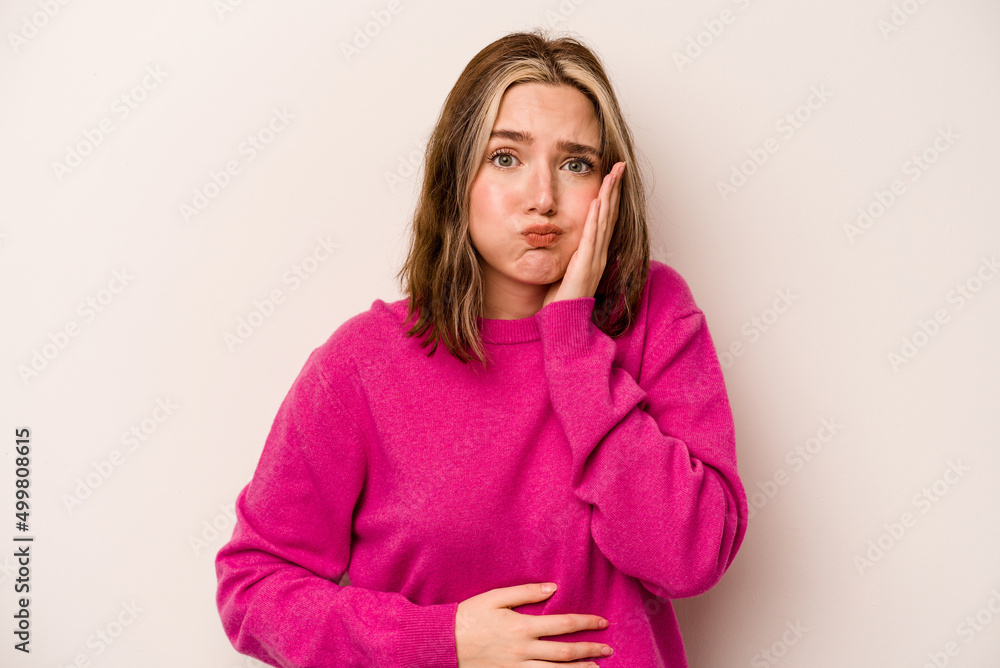 Young caucasian woman isolated on white background blows cheeks, has tired expression. Facial expression concept. Young caucasian woman isolated on white background blows cheeks, has tired expression. Facial expression concept.
