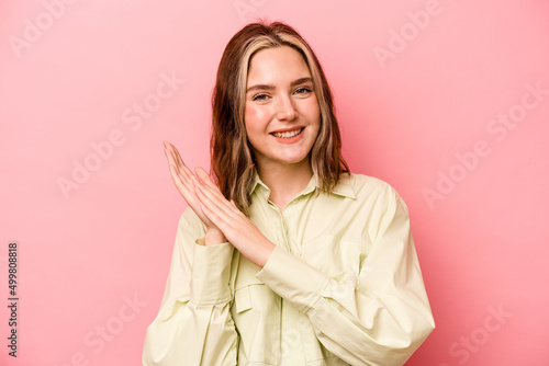 Young caucasian woman isolated on pink background feeling energetic and comfortable, rubbing hands confident. © Asier