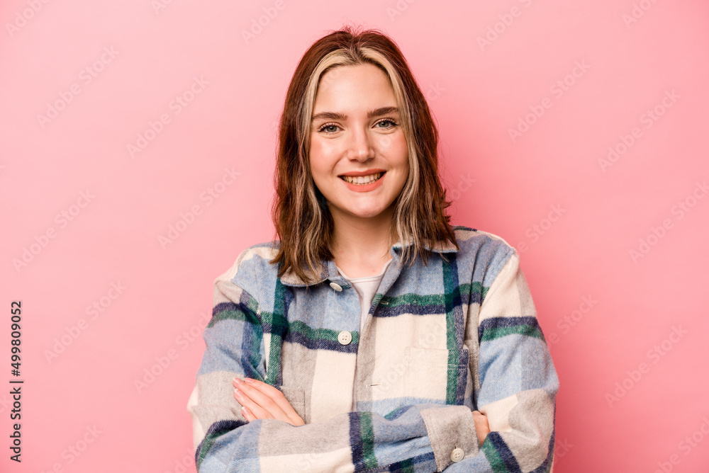 Young caucasian woman isolated on pink background who feels confident, crossing arms with determination. Young caucasian woman isolated on pink background who feels confident, crossing arms with determination.