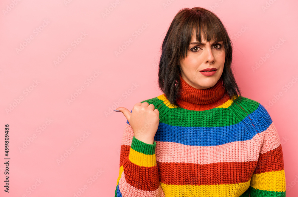 Young caucasian woman isolated on pink background shocked pointing with index fingers to a copy space. Young caucasian woman isolated on pink background shocked pointing with index fingers to a copy space.