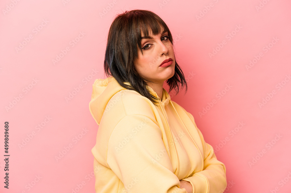 Young caucasian woman isolated on pink background suspicious, uncertain, examining you. Young caucasian woman isolated on pink background suspicious, uncertain, examining you.