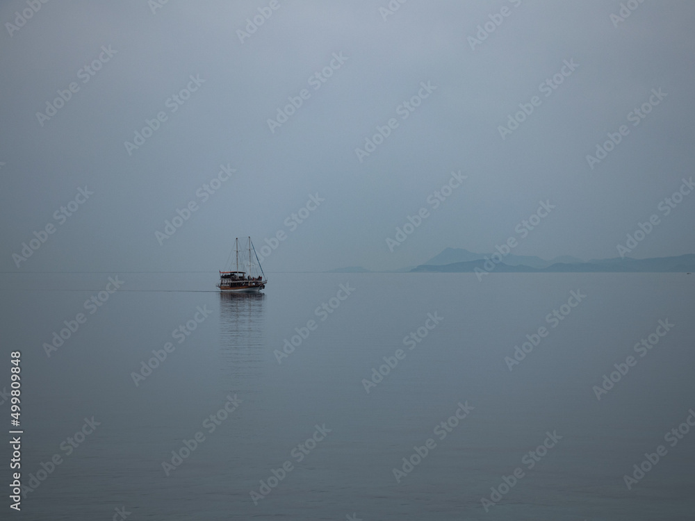 it's a gloomy weather because the dust is transported, boat on the sea antalya 