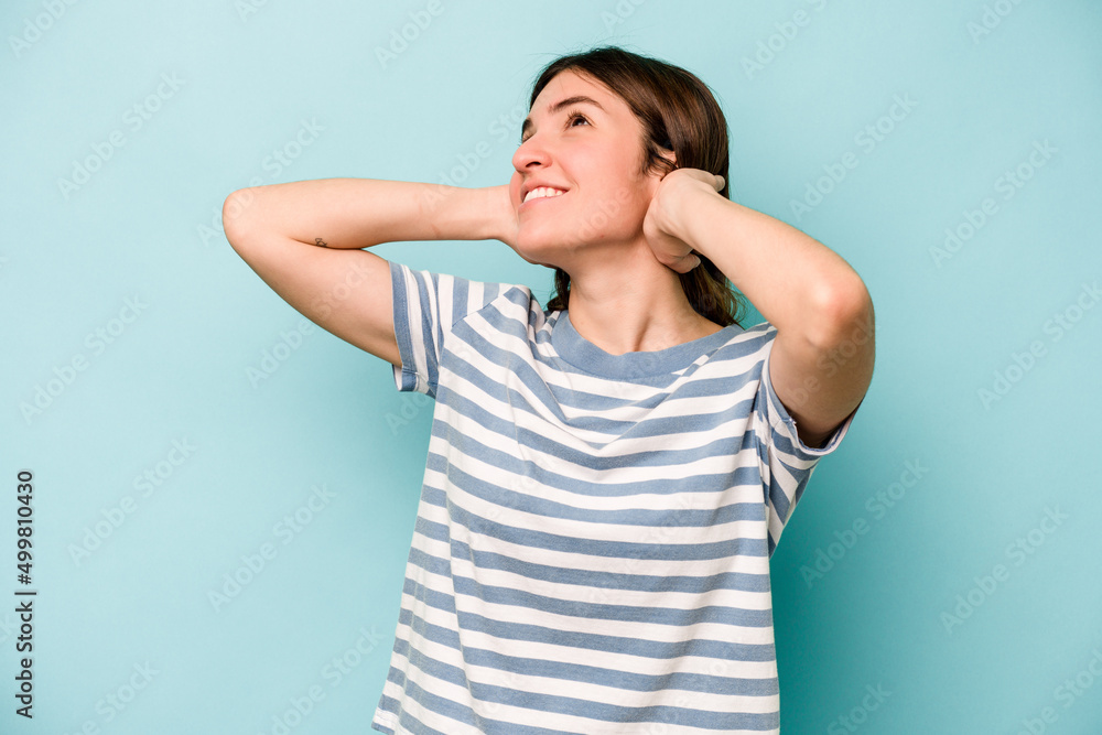 Young caucasian woman isolated on blue background feeling confident, with hands behind the head. Young caucasian woman isolated on blue background feeling confident, with hands behind the head.