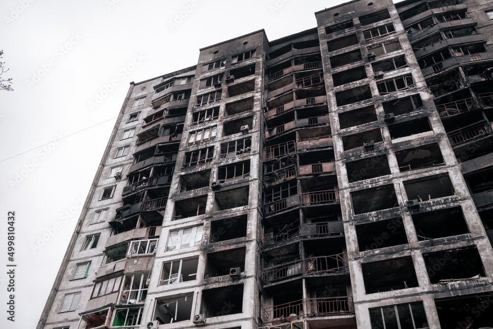 Residential building after a fire from a rocket hit. Bottom view of a high residential building burnt down by a bomb Residential building after a fire from a rocket hit. Bottom view of a high residential building burnt down by a bomb