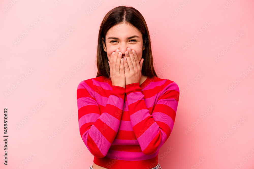 Young caucasian woman isolated on pink background laughing about something, covering mouth with hands. Young caucasian woman isolated on pink background laughing about something, covering mouth with hands.