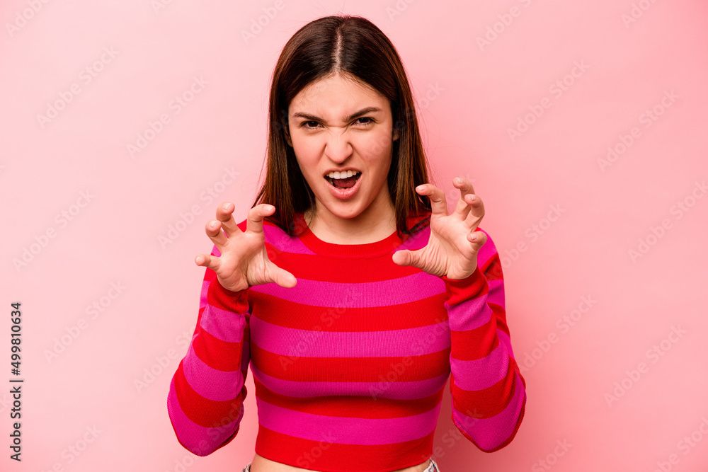 Young caucasian woman isolated on pink background showing claws imitating a cat, aggressive gesture. Young caucasian woman isolated on pink background showing claws imitating a cat, aggressive gesture.