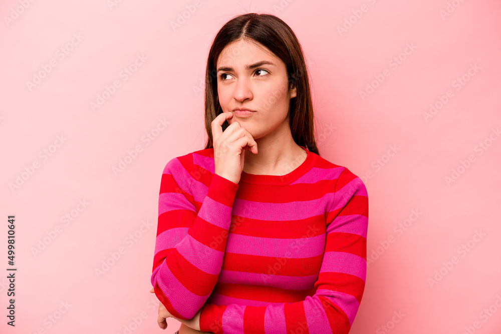 Young caucasian woman isolated on pink background thinking and looking up, being reflective, contemplating, having a fantasy. Young caucasian woman isolated on pink background thinking and looking up, being reflective, contemplating, having a fantasy.