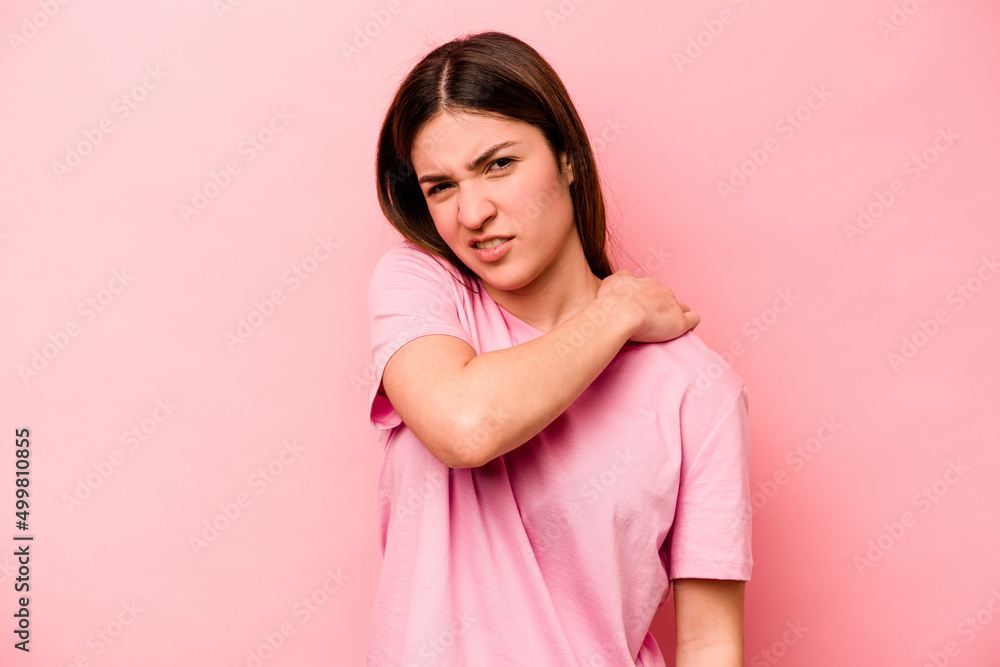 Young caucasian woman isolated on pink background having a shoulder pain. Young caucasian woman isolated on pink background having a shoulder pain.