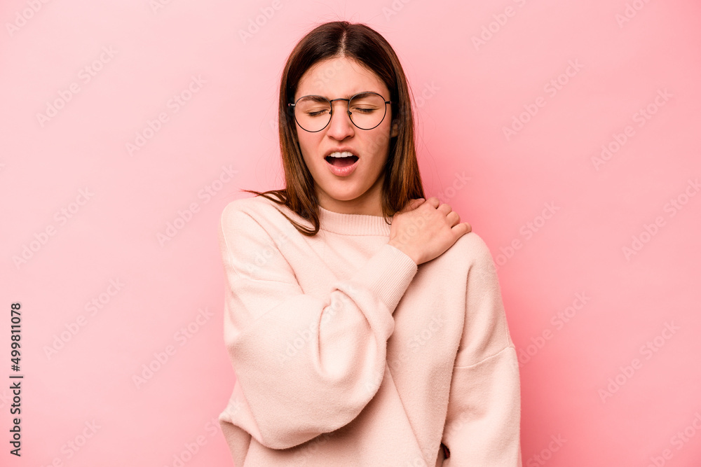 Young caucasian woman isolated on pink background having a shoulder pain. Young caucasian woman isolated on pink background having a shoulder pain.
