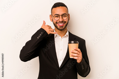 Young business hispanic man holding takeaway coffee isolated on white background showing a mobile phone call gesture with fingers.