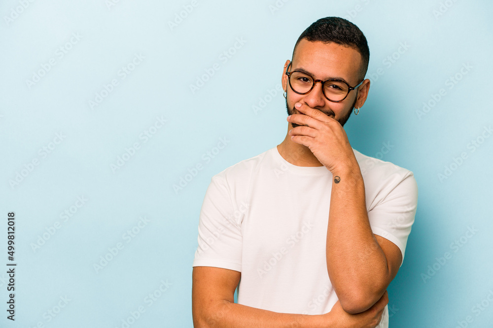 Young hispanic man isolated on blue background laughing happy, carefree, natural emotion. Young hispanic man isolated on blue background laughing happy, carefree, natural emotion.