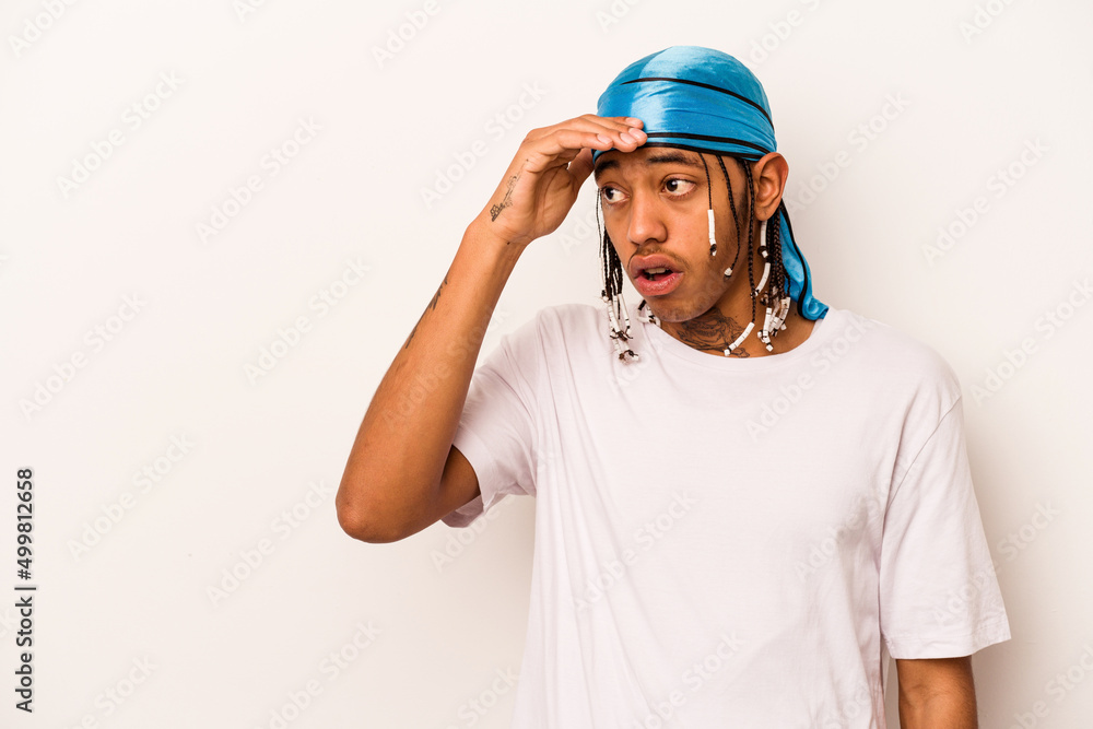 Young African American man isolated on white background looking far away keeping hand on forehead.