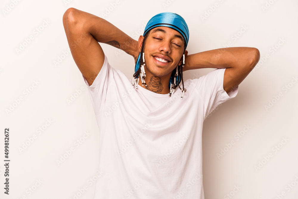 Young African American man isolated on white background stretching arms, relaxed position. Young African American man isolated on white background stretching arms, relaxed position.