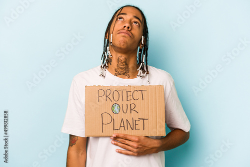 Foto Young African American man holding protect our planet placard isolated on blue b