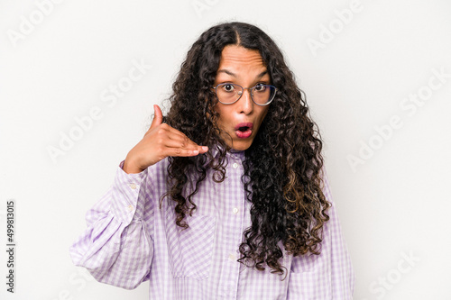 Young hispanic woman isolated on white background laughing about something, covering mouth with hands.