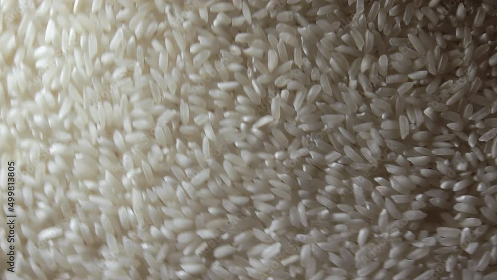 Dry Uncooked White Rice Background Rotating Right - Top View. Scattered Raw Long Grain Rice. Asian Cuisine and Culture. Healthy Eating Ingredients. Diet Food. Angular Rotation Clockwise Dry Uncooked White Rice Background Rotating Right - Top View. Scattered Raw Long Grain Rice. Asian Cuisine and Culture. Healthy Eating Ingredients. Diet Food. Angular Rotation Clockwise