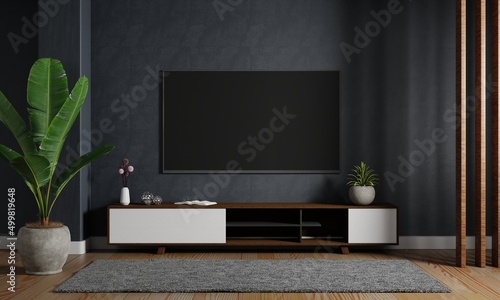 Modern mockup televion tv hanging on the dark blue wall background wtih wooden cabinet in living room. Interior architecture and entertainment concept. 3D illustration rendering