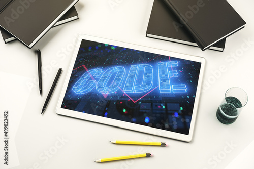 Creative Code word hologram on modern digital tablet display, artificial intelligence and neural networks concept. Top view. 3D Rendering