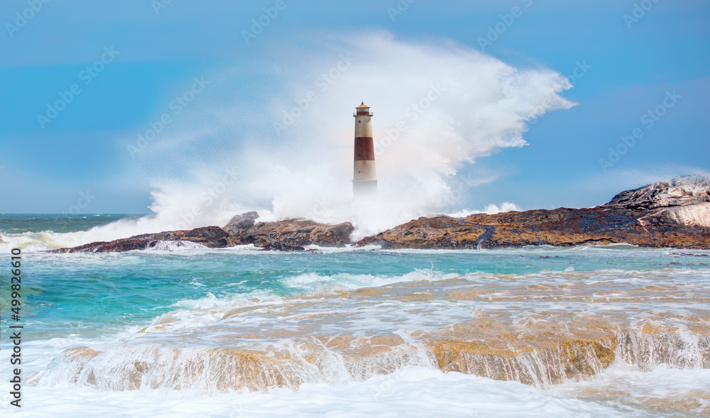 Beautiful red and white lighthouse on the rocks with strong sea wave - Namibia, Africa