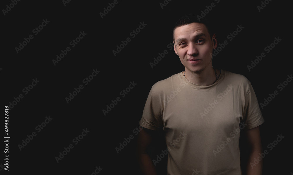 Handsome guy posing in studio on isolated black background. Studio portrait with one light source. Handsome guy posing in studio on isolated black background. Studio portrait with one light source.