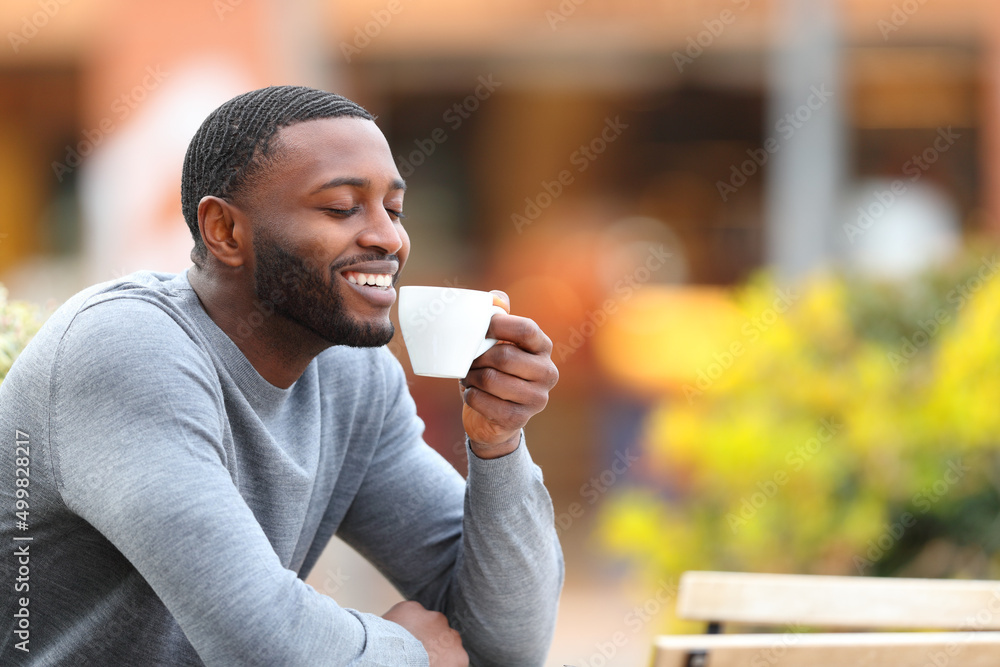 Happy man with black skin drinking coffee in a bar Happy man with black skin drinking coffee in a bar