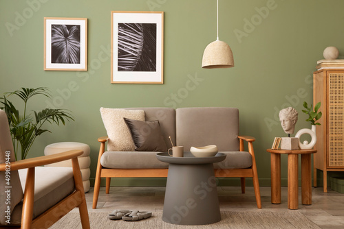 Elegant composition of living room interior. Modern scandi sofa, side table, rattan commode, plants and creative personal accessories. Sage green wall. Template. Copy space. © FollowTheFlow