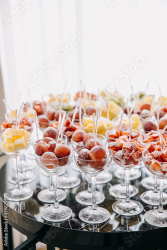 Various fresh fruits and berries in glasses at a party reception. Healthy dessert concept.