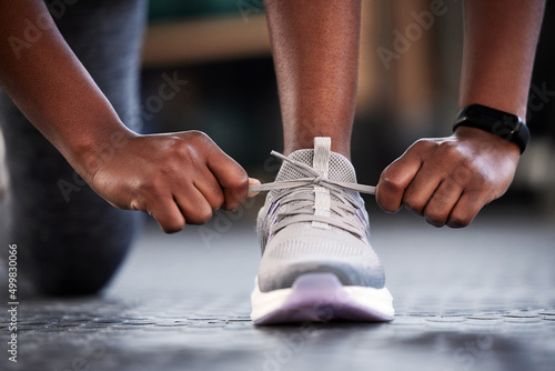 Take a small step every day and just keep going. Cropped shot of an unrecognizable woman tying her shoelaces while at the gym.