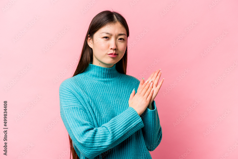 Obraz premium Young Chinese woman isolated on pink background feeling energetic and comfortable, rubbing hands confident.