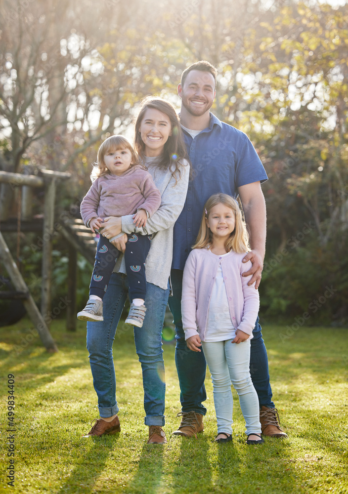 Family is everything. Full length portrait of an affectionate young family of four posing in the garden at home. Family is everything. Full length portrait of an affectionate young family of four posing in the garden at home.