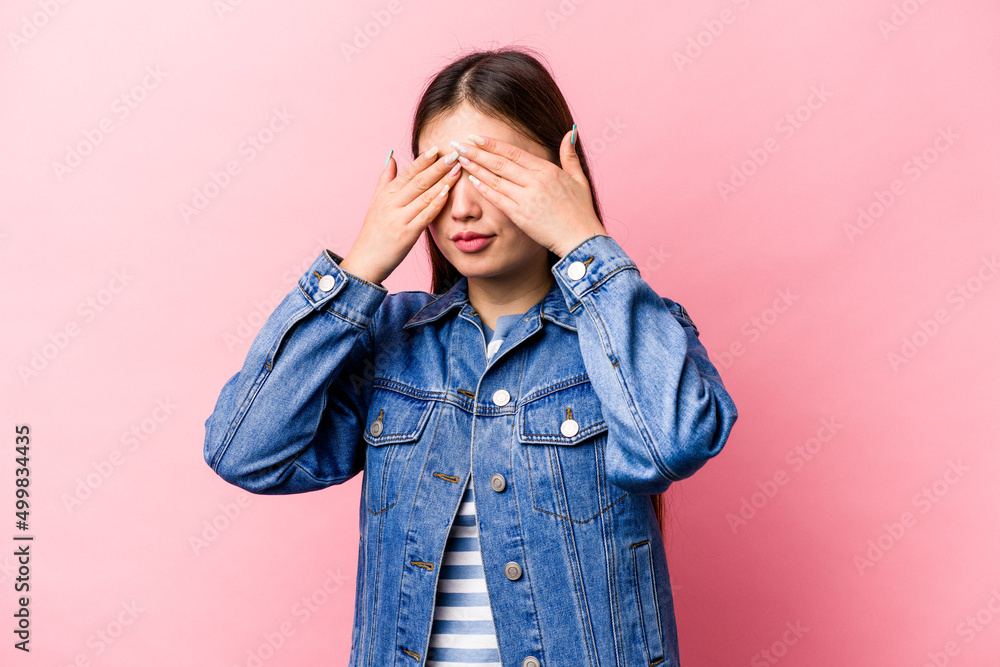 Young Chinese woman isolated on pink background afraid covering eyes with hands. Young Chinese woman isolated on pink background afraid covering eyes with hands.