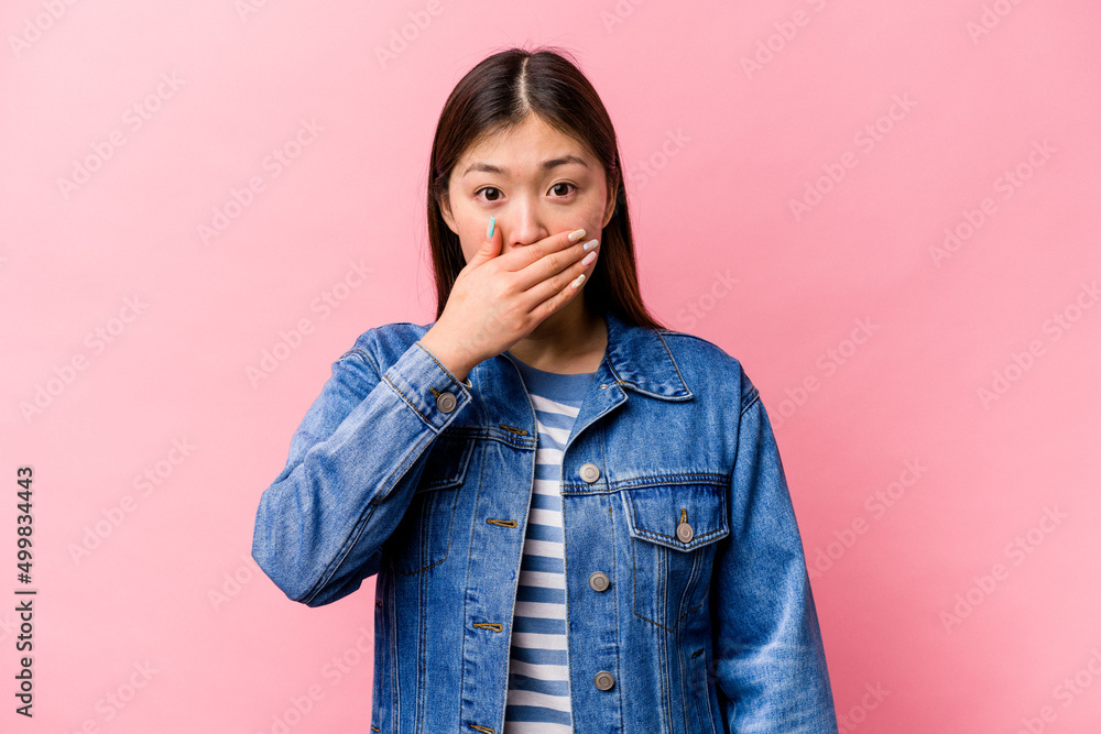 Young Chinese woman isolated on pink background covering mouth with hands looking worried. Young Chinese woman isolated on pink background covering mouth with hands looking worried.