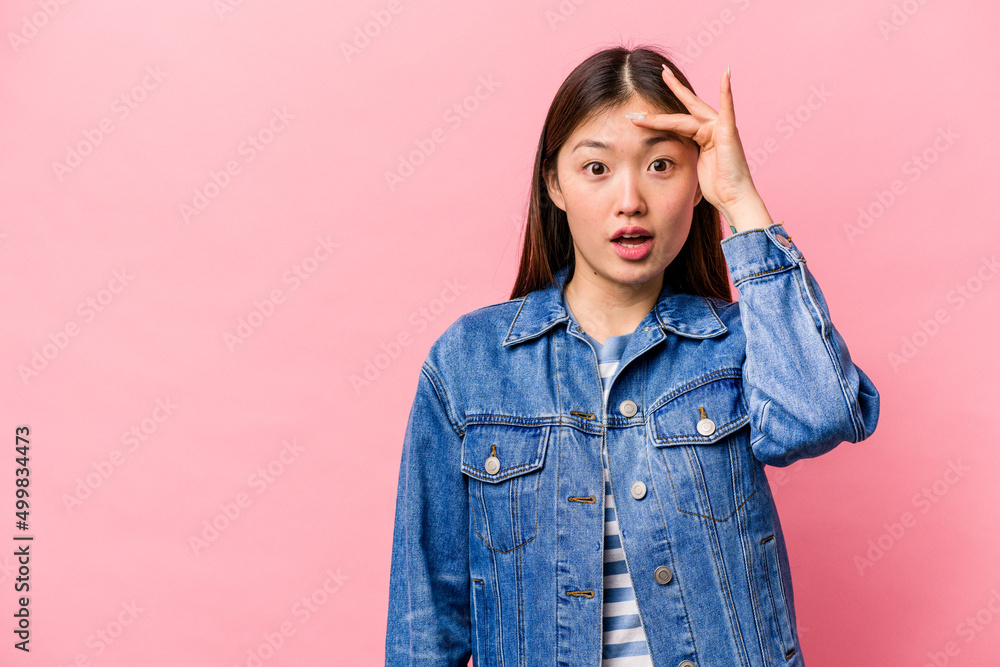 Young Chinese woman isolated on pink background looking far away keeping hand on forehead. Young Chinese woman isolated on pink background looking far away keeping hand on forehead.